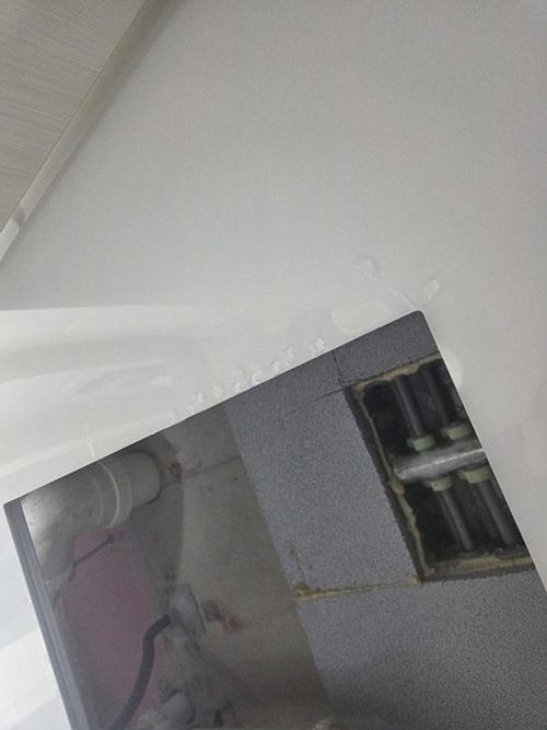 누수탐지 벽지 얼룩의 번짐 방향을 살펴보는 점검 장면