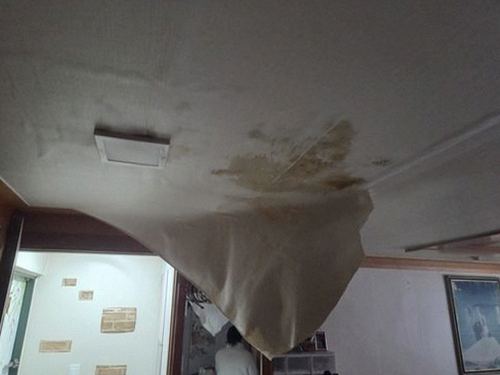 누수탐지 벽지 얼룩 부위를 관찰하며 위치를 기록하는 장면