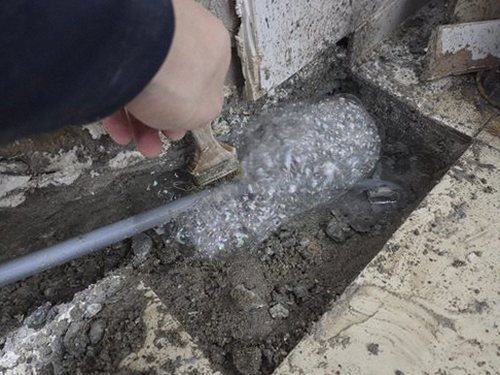 누수탐지 배관 보수 후 압력 점검과 바닥 복구를 진행하는 모습