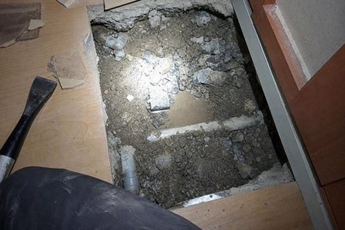 누수탐지 욕실 배수구 주변의 습기 흔적과 벽면 얼룩을 점검하는 모습